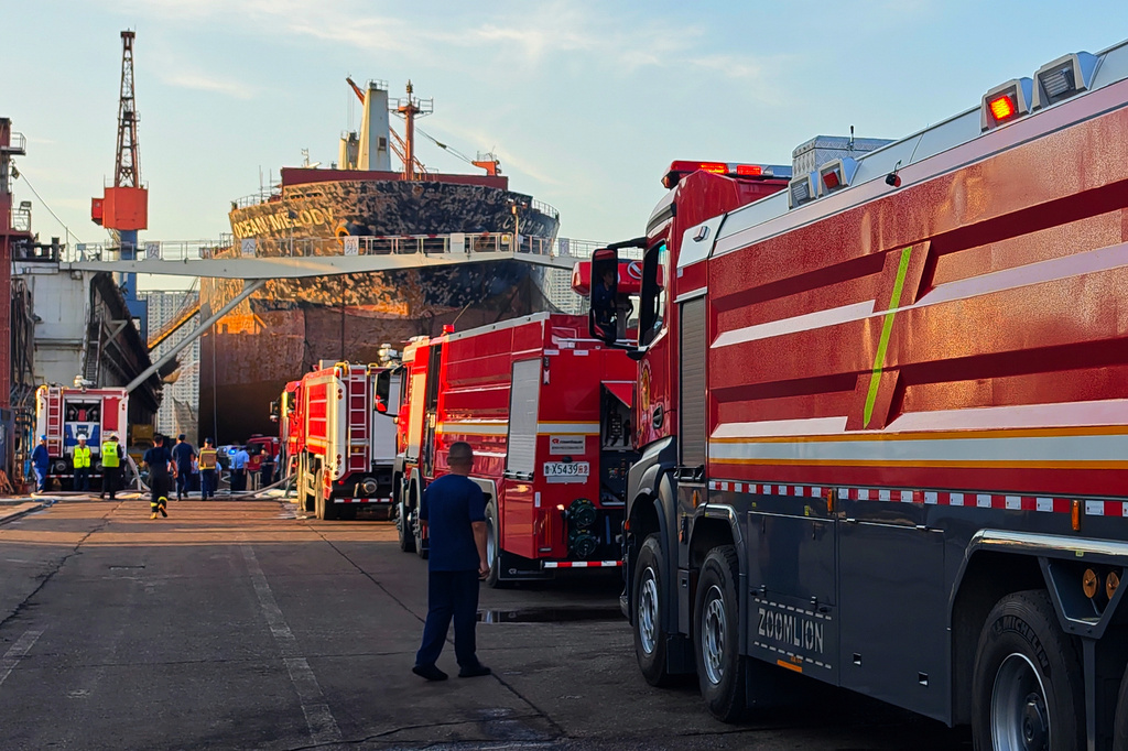 In this photo released by Xinhua News Agency, firefighters and crews gather near a repair cargo ship after it caught fire at a port in Qingdao, east China's Shandong Province, Thursday, Sept. 10, 2026. (Li Aoqiu/Xinhua via AP)