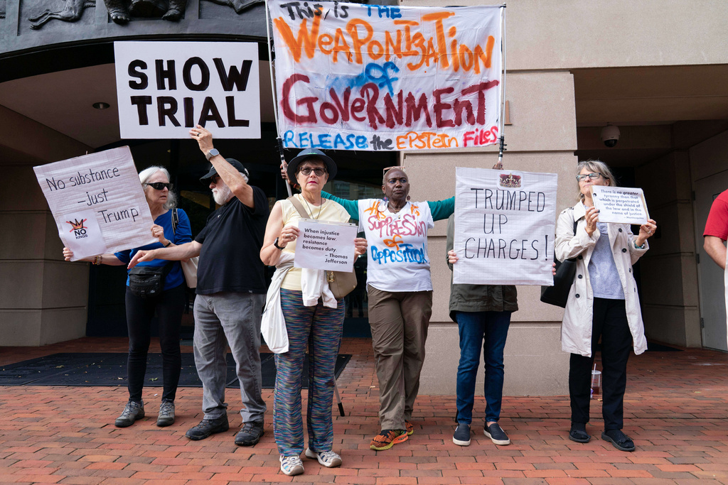 Demonstrators protest outside of the Albert V. Bryan United States Courthouse before the arrival of former FBI Director James Comey, for his arraignment in Alexandria, Va., Wednesday, Oct. 8, 2025. (AP Photo/Jose Luis Magana)