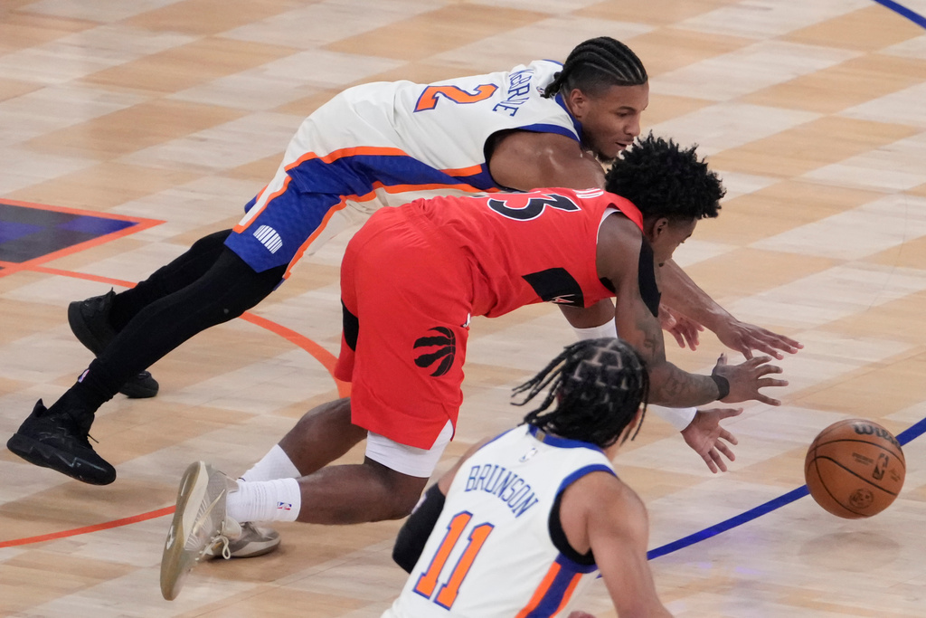 Toronto Raptors guard Jamal Shead (23) and New York Knicks guard Miles McBride (2) reach for the ball during the first half of an NBA basketball game Sunday, Nov. 30, 2025, in New York. (AP Photo/Yuki Iwamura)