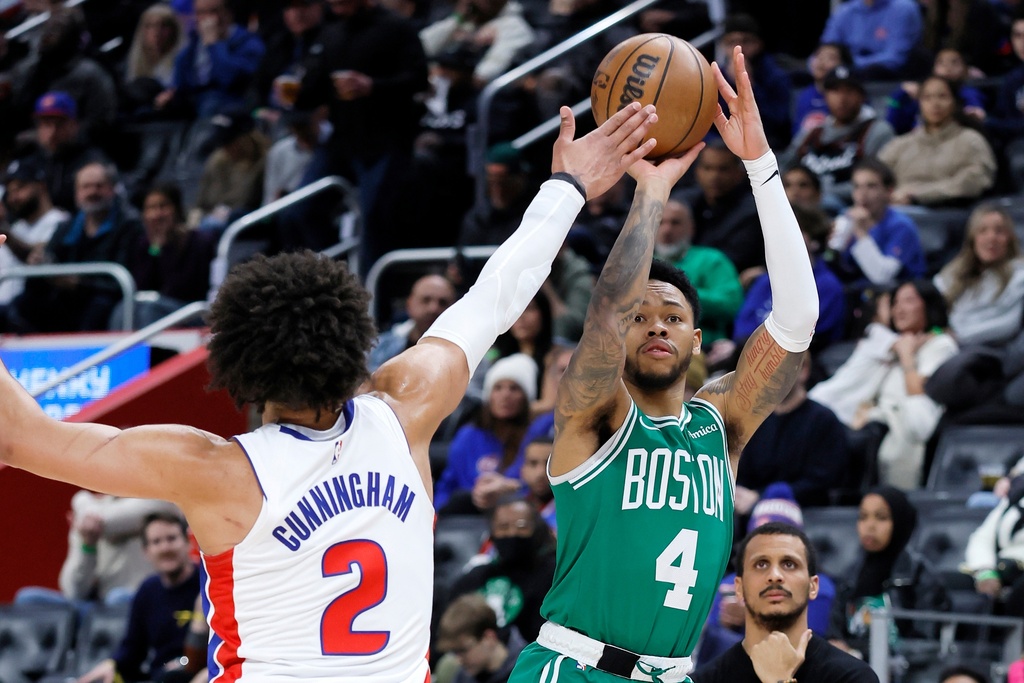 Boston Celtics guard Anfernee Simons (4) takes a shot against Detroit Pistons guard Cade Cunningham (2) during the first half of an NBA basketball game Monday, Jan. 19, 2026, in Detroit. (AP Photo/Duane Burleson)