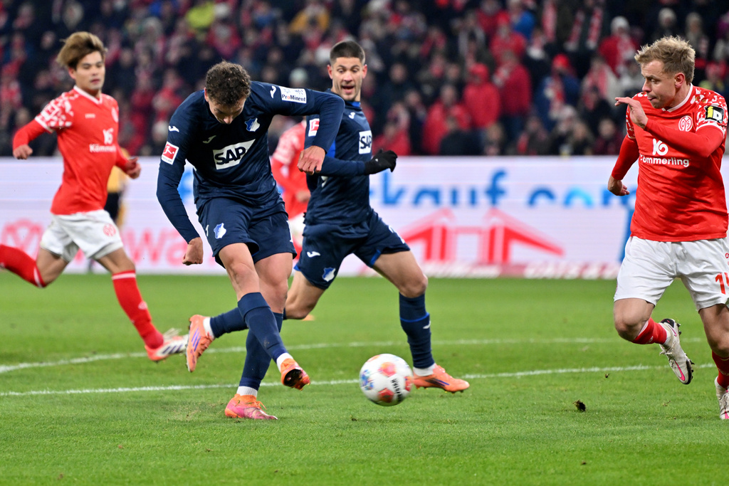 Hoffenheim's Fisnik Asllani, center, shoots on goal during the German Bundesliga soccer match between FSV Mainz 05 and TSG 1899 Hoffenheim in Mainz, Germany, Friday, Nov. 21, 2025. (Torsten Silz/dpa via AP)