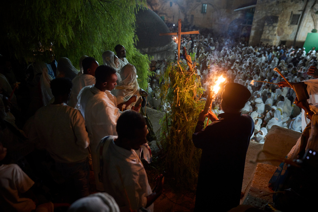 An Ethiopian Orthodox monk lights a bonfire on the eve of the Meskel holiday at the Ethiopian monks' village, Deir Al‑Sultan, located on the rooftop of the Church of the Holy Sepulcher in Jerusalem's Old City, Saturday, Sept. 26, 2026. (AP Photo/Ohad Zwigenberg)