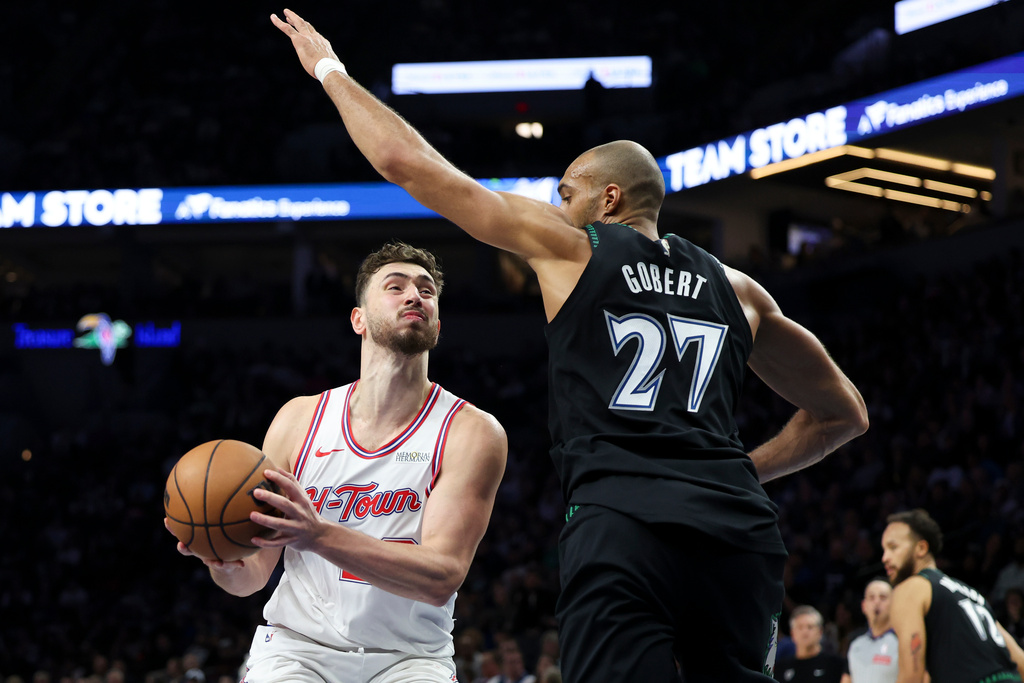 Houston Rockets center Alperen Sengun, left, drives toward the hoop against Minnesota Timberwolves center Rudy Gobert (27) during the first half of an NBA basketball game, Wednesday, March 25, 2026, in Minneapolis. (AP Photo/Ellen Schmidt)