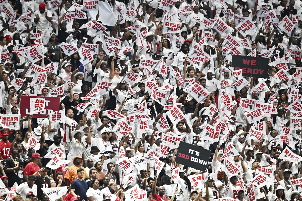 Atlanta Falcons fans wave flags during the first half of an NFL football game against Tampa Bay Buccaneers, Sunday, Sept. 7, 2025, in Atlanta. (AP Photo/Danny Karnik)