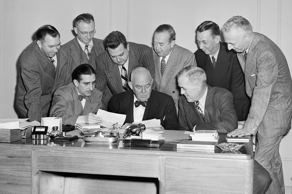 FILE - A group of sportswriters confer with Grantland Rice, noted sports authority, seated at center, in Chicago, Nov. 13, 1949, to select Look Magazine's All-America college football team. Seated, from left: Hal Middlesworth, Daily Oklahoman; Rice; and Bert McGrane, Des Moines Register. Standing from left: Raymond Johnson, Nashville Tennessean; Francis Powers, Chicago Daily News; Tim Cohane, Look Magazine; Charley Johnson, Minneapolis Star; Bill Leiser, San Francisco Chronicle, and HG. Salsinger, Detroit News. (AP Photo/Paul Cannon, File)