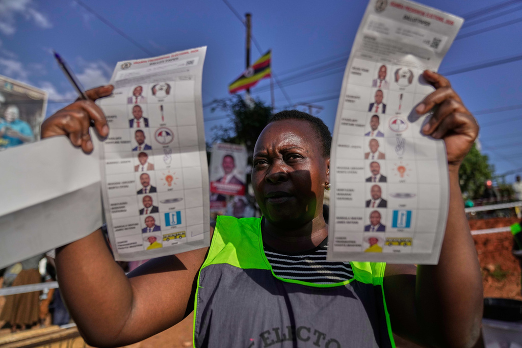 An election official holds up unmarked ballots during the vote count after polls closed for the presidential election, at a polling center in Kampala, Uganda, Thursday, Jan. 15, 2026. (AP Photo/Brian Inganga)