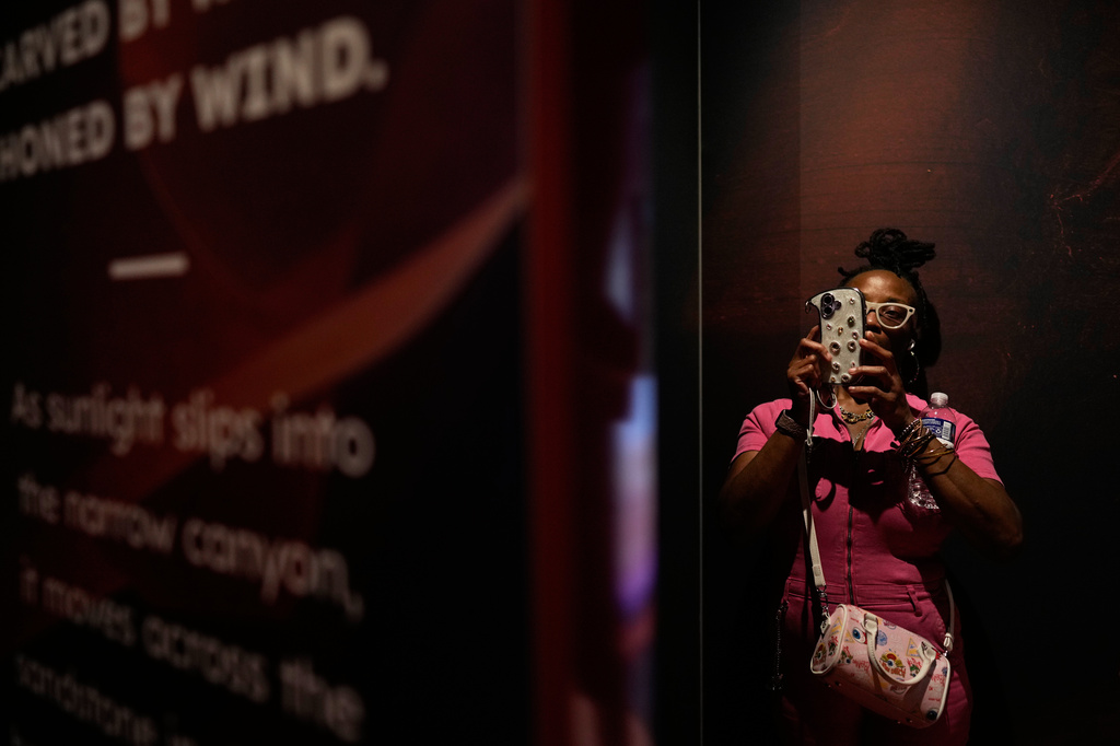 Shawanda Jones, from Arizona, uses a smartphone in Arizona's interactive exhibit during the Great American State Fair on Friday, June 26, 2026, in Washington. (AP Photo/Carolyn Kaster)