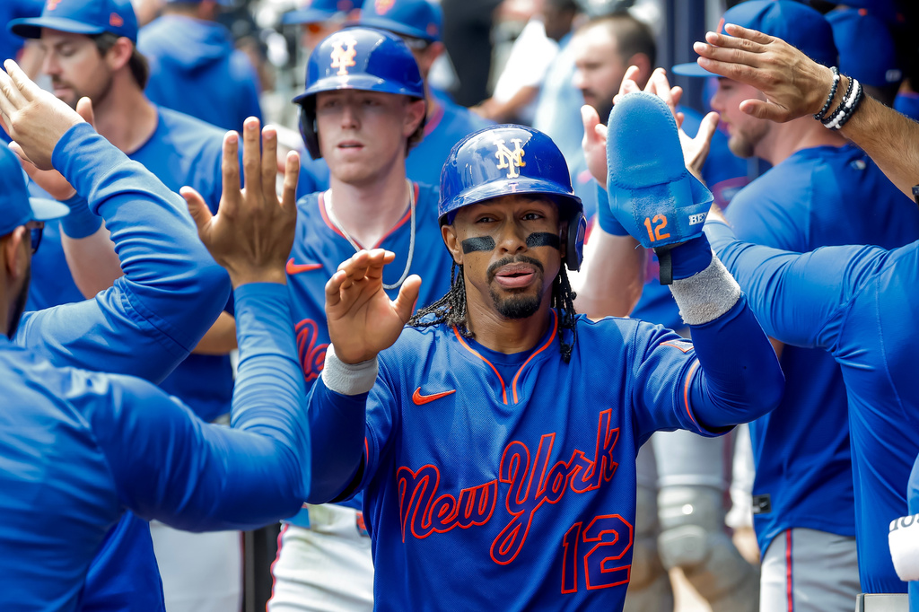New York Mets' Francisco Lindor (12) and Brett Baty, behind, are greeted in the dugout after they scored against the Atlanta Braves during the second inning of a baseball game, Sunday, July 5, 2026, in Atlanta. (AP Photo/Erik S. Lesser)