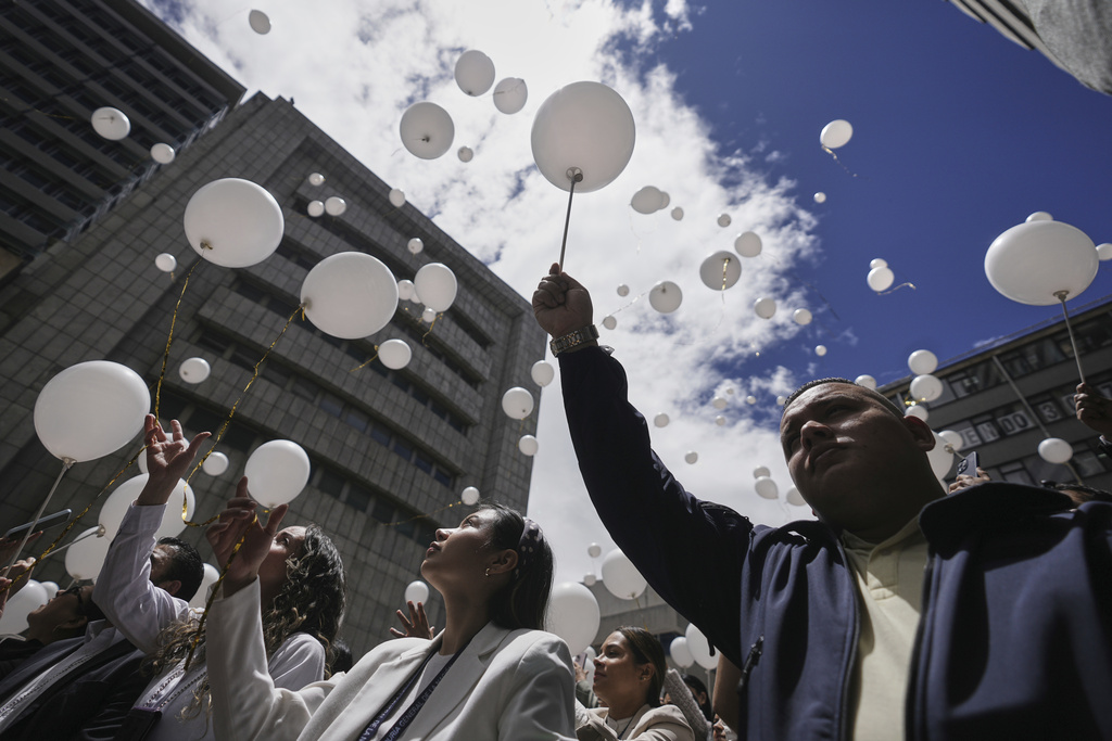 Employees of the attorney general's office release balloons during a ceremony to honor presidential hopeful and opposition Sen. Miguel Uribe, after his death more than two months after he was shot during a political rally, in Bogota, Colombia, Monday, Aug. 11, 2025. (AP Photo/Ivan Valencia)