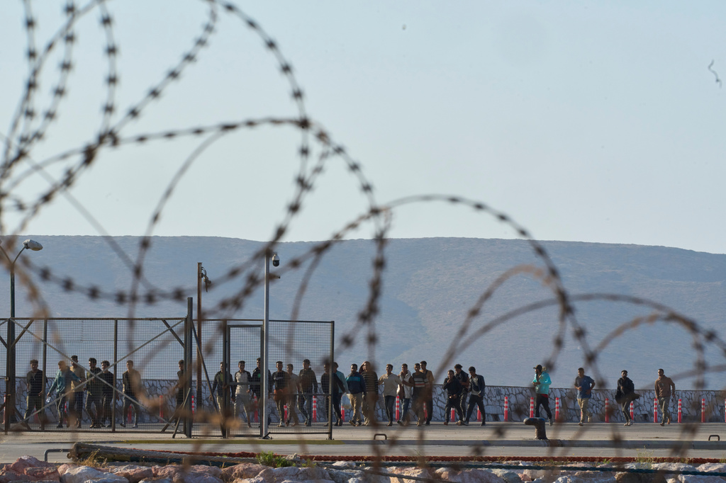 FILE - Migrants rescued south of Crete walk after their arrival at the the port of Lavrio, Greece, on July 10, 2025. (AP Photo/Petros Giannakouris, File)