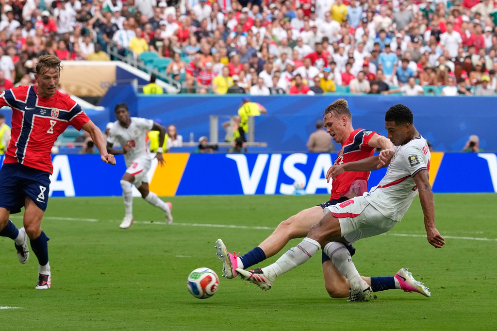 England's Jude Bellingham, right, scores his side's first goal during the World Cup quarterfinal soccer match between Norway and England in Miami Gardens, Fla., Saturday, July 11, 2026. (AP Photo/Rebecca Blackwell)