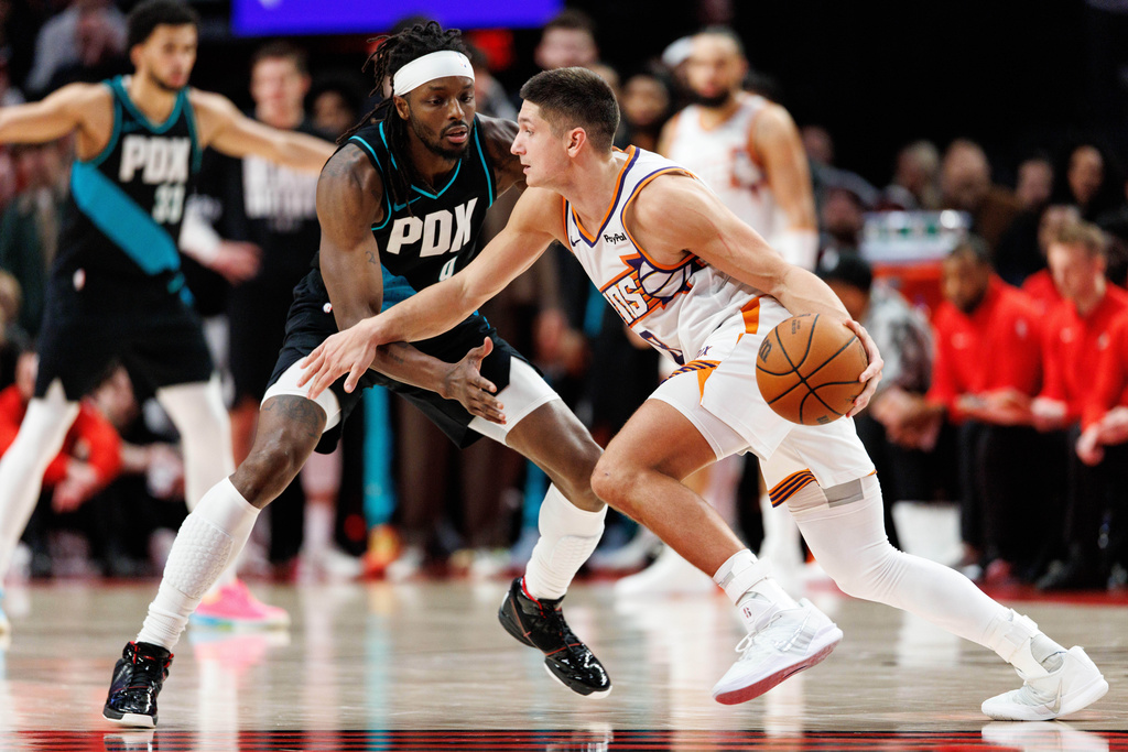 Phoenix Suns guard Grayson Allen, right, dribbles against Portland Trail Blazers forward Jerami Grant, left, during the second half of an NBA basketball game Tuesday, Feb. 3, 2026, in Portland, Ore. (AP Photo/Howard Lao)