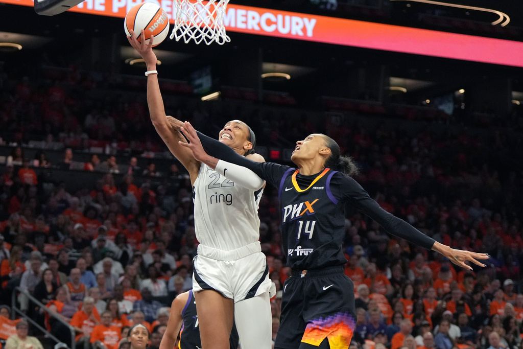 Las Vegas Aces center A'ja Wilson (22) gets fouled by Phoenix Mercury forward DeWanna Bonner during the first half of Game 3 of the WNBA basketball finals, Wednesday, Oct. 8, 2025, in Phoenix. (AP Photo/Rick Scuteri)