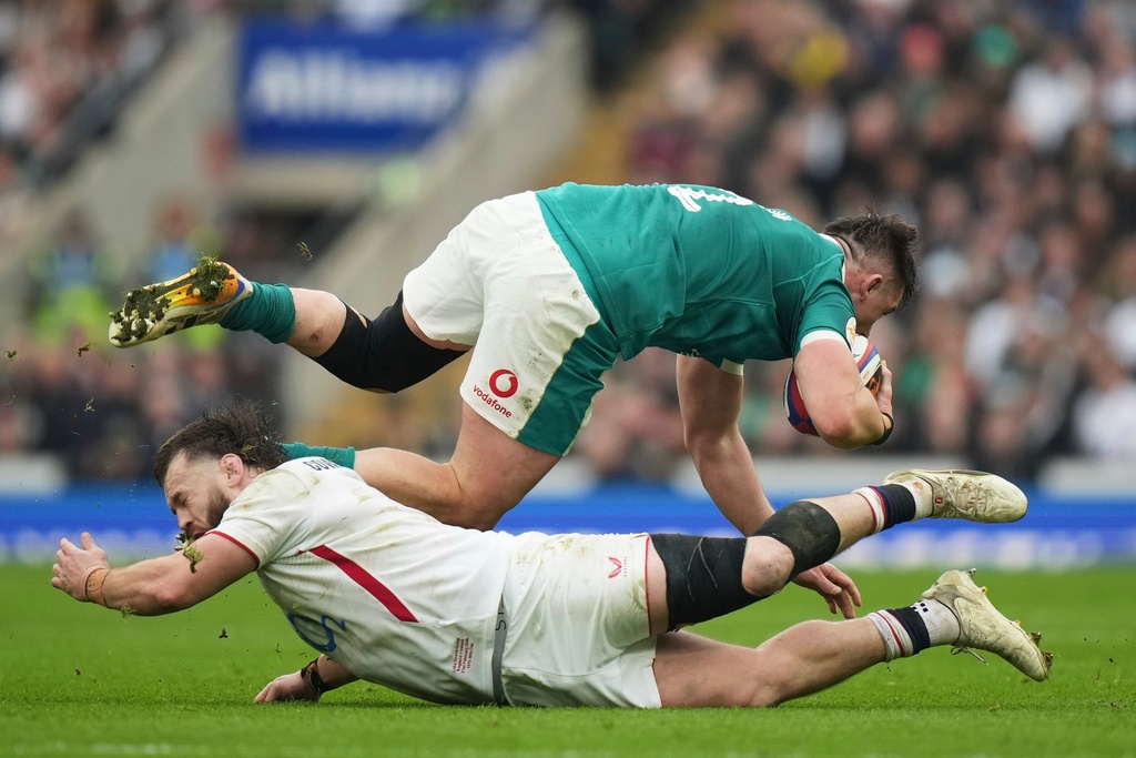 Ireland's Dan Sheehan, top, avoids a tackle by England's Luke Cowan-Dickie during the Six Nations rugby union match between England and Ireland in London, England, Saturday, Feb. 21, 2026. (AP Photo/Alastair Grant)