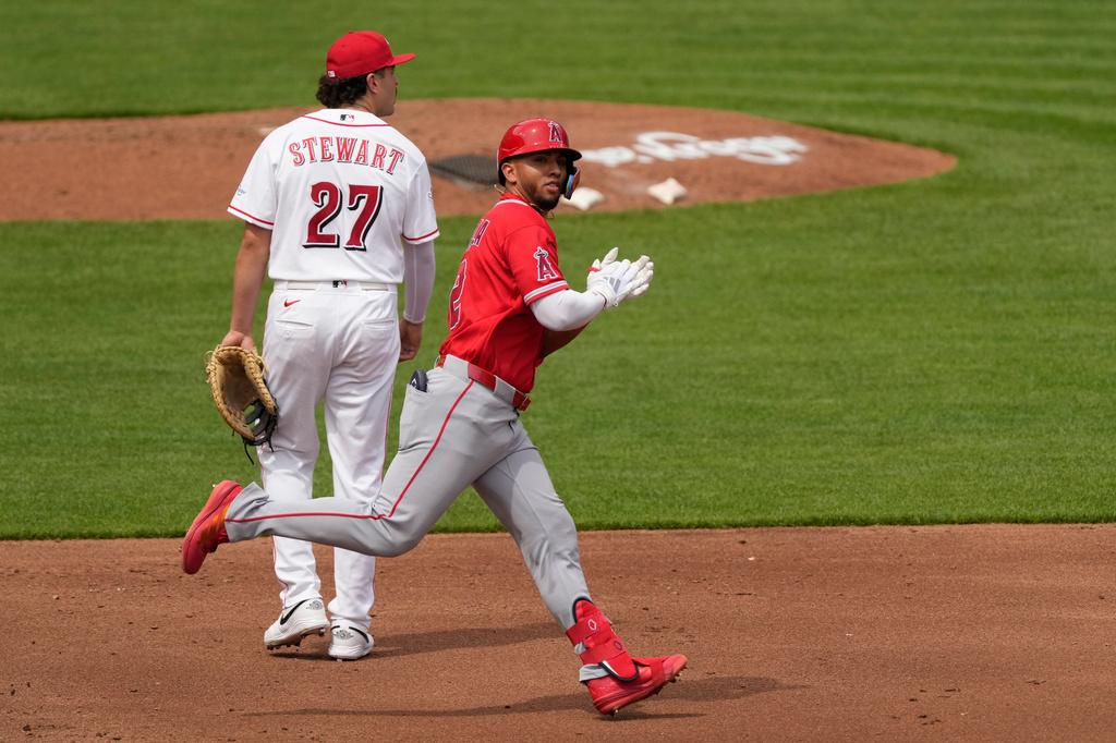 Los Angeles Angels' Oswald Peraza claps as he rounds the bases past Cincinnati Reds first baseman Sal Stewart (27) after hitting a solo home run in the fourth inning of a baseball game in Cincinnati, Sunday, April 12, 2026. (AP Photo/Carolyn Kaster)