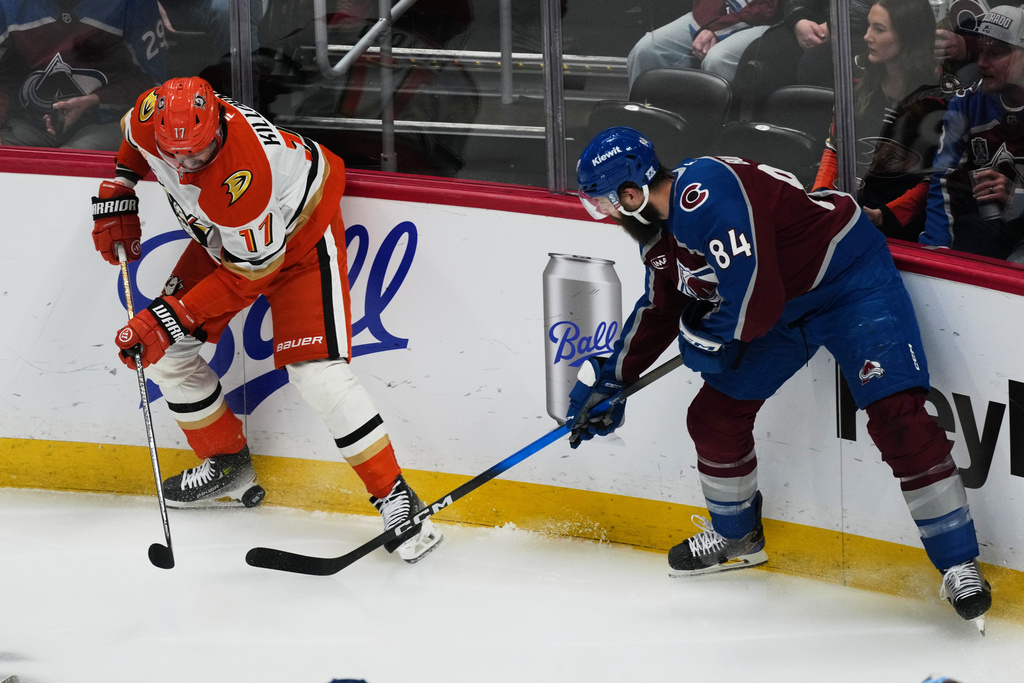 Anaheim Ducks left wing Alex Killorn, left, battles for control of the puck with Colorado Avalanche defenseman Brent Burns in the first period of an NHL hockey game Wednesday, Jan. 21, 2026, in Denver. (AP Photo/David Zalubowski)