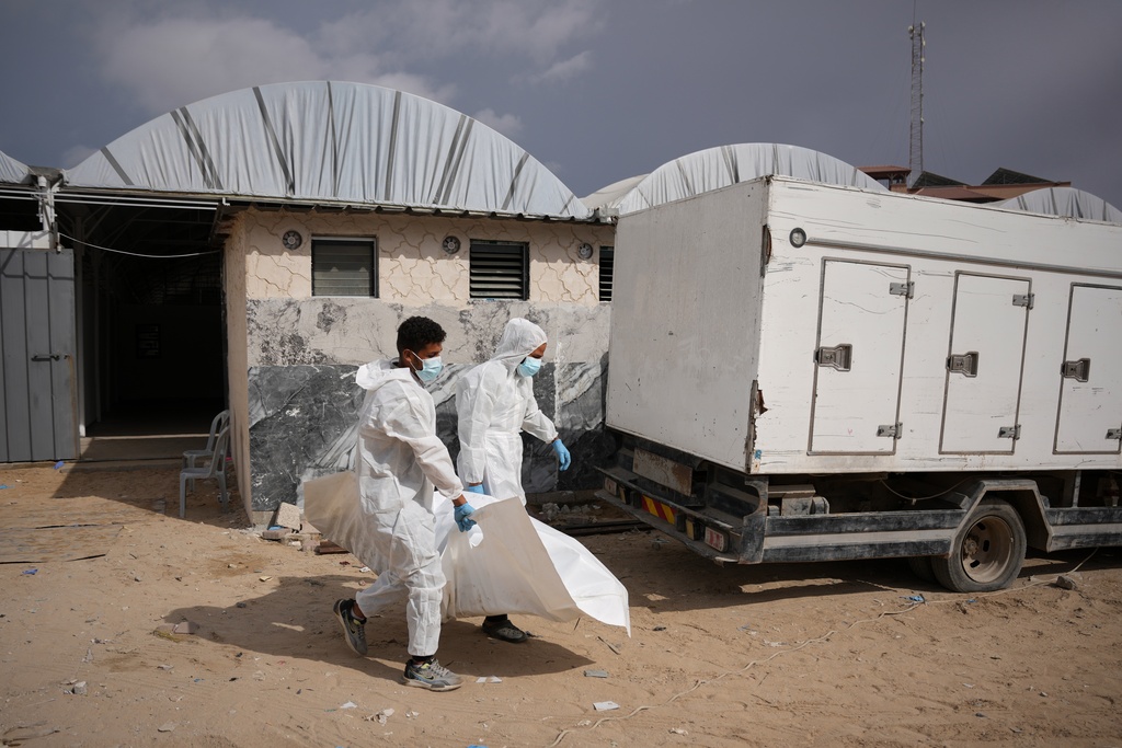 Bodies of unidentified Palestinians returned from Israel as part of the ceasefire deal are carried in Nasser Hospital in Khan Younis, Gaza Strip, Friday, Nov. 14, 2025. (AP Photo/Abdel Kareem Hana)