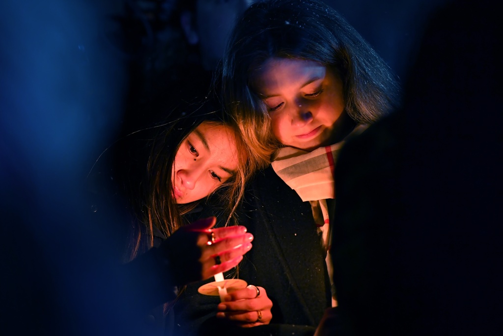 People hold candles during a vigil, Sunday, Dec. 14, 2025, in Providence, R.I., for those injured or killed in the Saturday shooting on the campus of Brown University. (AP Photo/Steven Senne)