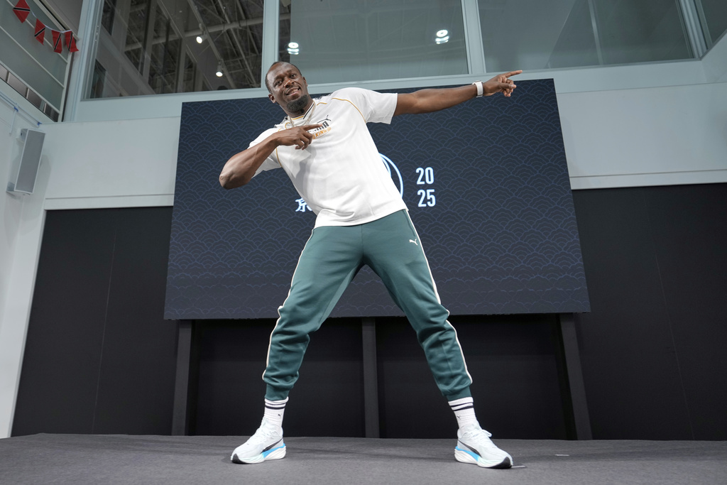 Former sprinter, Jamaica's Usain Bolt makes his signature pose at the end of a press conference ahead of the World Athletics Championships in Tokyo, Japan, Thursday, Sept. 11, 2025. (AP Photo/Eugene Hoshiko)
