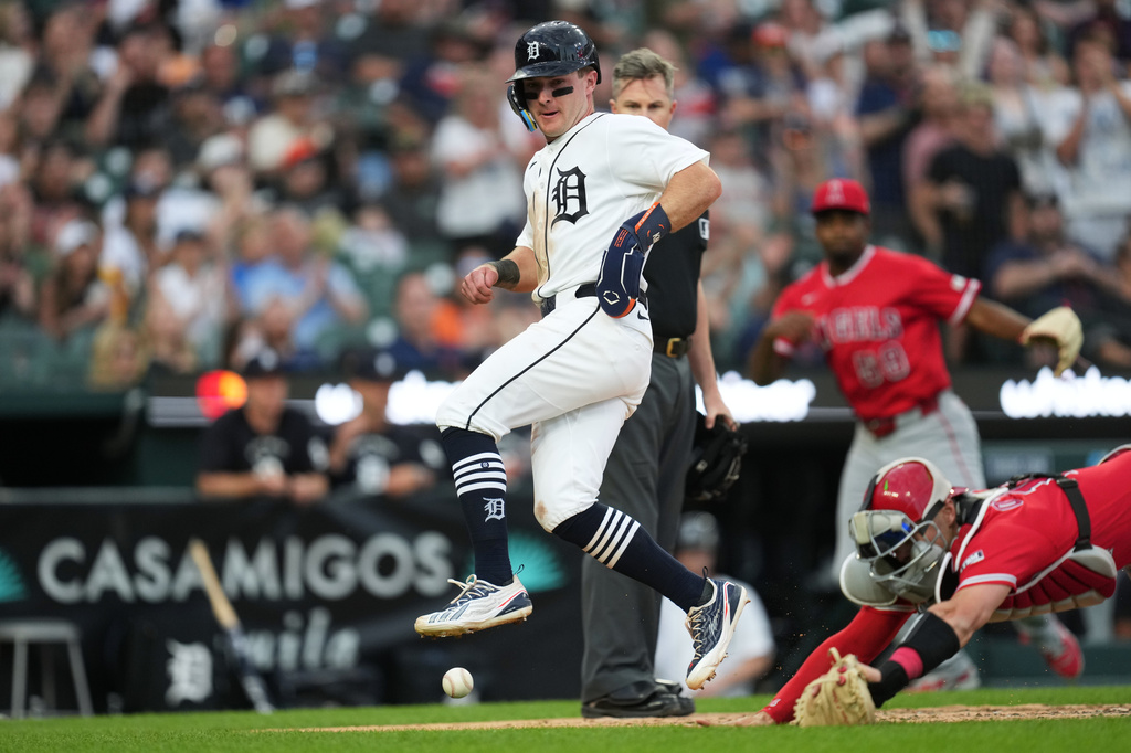 Detroit Tigers' Kevin McGonigle, left, avoids the ball while scoring as Los Angeles Angels catcher Logan O'Hoppe (14) attempts to stop the throw during the fifth inning of a baseball game Wednesday, May 27, 2026, in Detroit. (AP Photo/Paul Sancya)