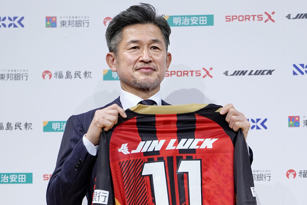 Japanese soccer player Kazuyoshi Miura poses with uniform of third-division J-League team Fukushima United. during a press conference in Tokyo, Japan, on Jan. 9, 2026. (Yuya Shino/Kyodo News via AP)