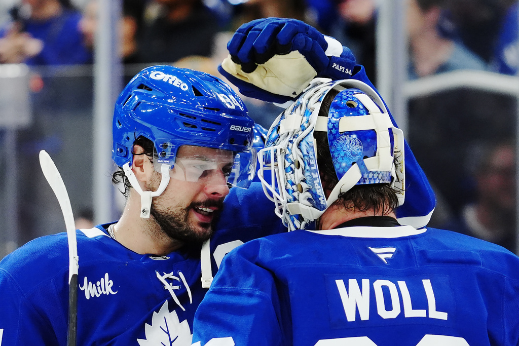 Toronto Maple Leafs' Auston Matthews, left, and goaltender Joseph Woll, right, celebrate after defeating the Vancouver Canucks in NHL hockey game action in Toronto, Saturday, Jan. 10, 2026. (Frank Gunn/The Canadian Press via AP)