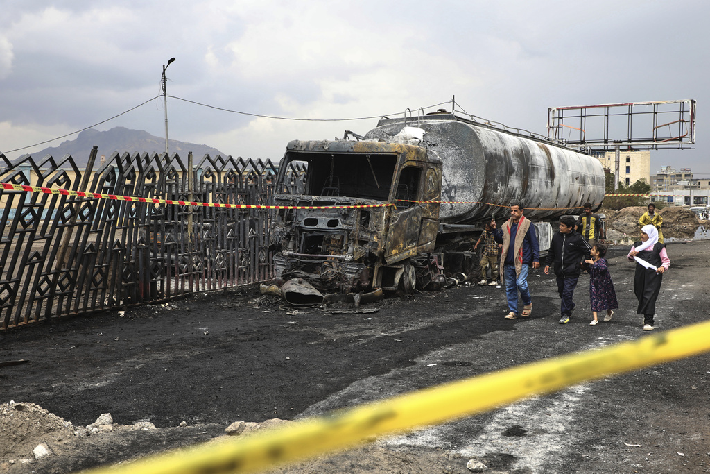People walk past the wreckage of a fuel truck destroyed in Israeli airstrikes on Sunday, in Sanaa, Yemen, Monday, Aug. 25, 2025. (AP Photo)