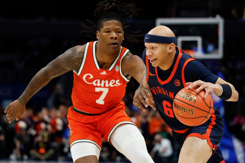 Virginia guard Jacari White (6) drives to the basket against Miami forward Shelton Henderson during the first half of an NCAA college basketball game in the semifinals of the Atlantic Coast Conference tournament in Charlotte, N.C., Friday, March 13, 2026. (AP Photo/Nell Redmond)