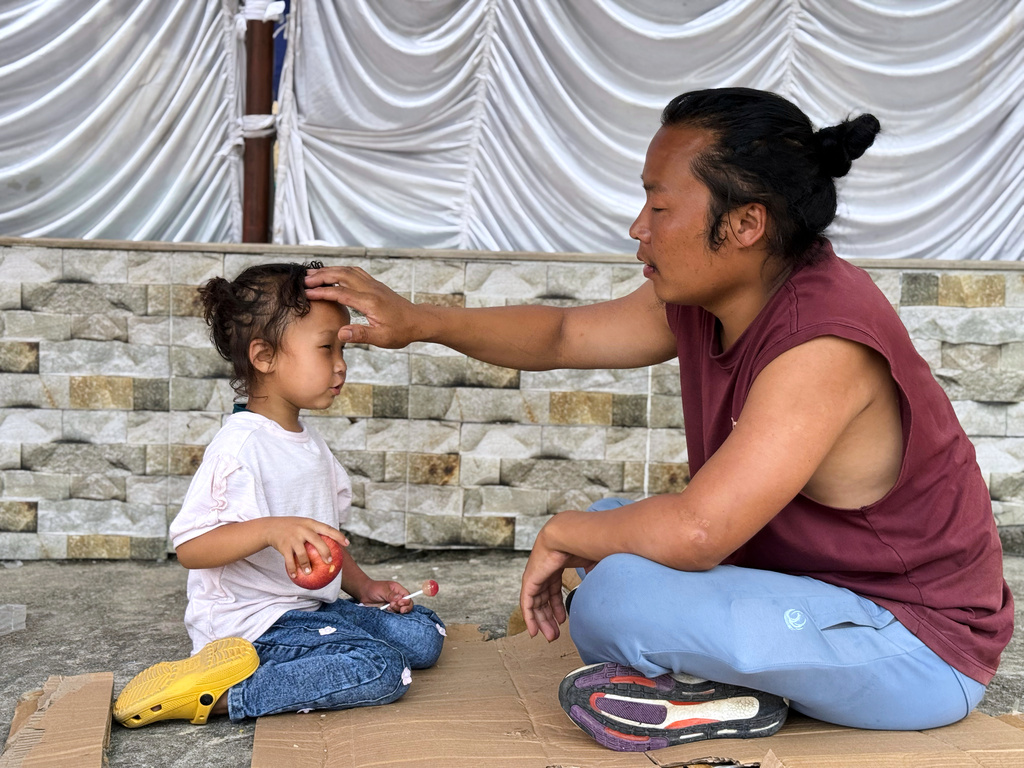 Survivor Tsering Gelbu Lama sits with his daughter at a monastery in Kathmandu, Nepal, Monday, Aug. 31, 2026. (AP Photo/Niranjan Shrestha)
