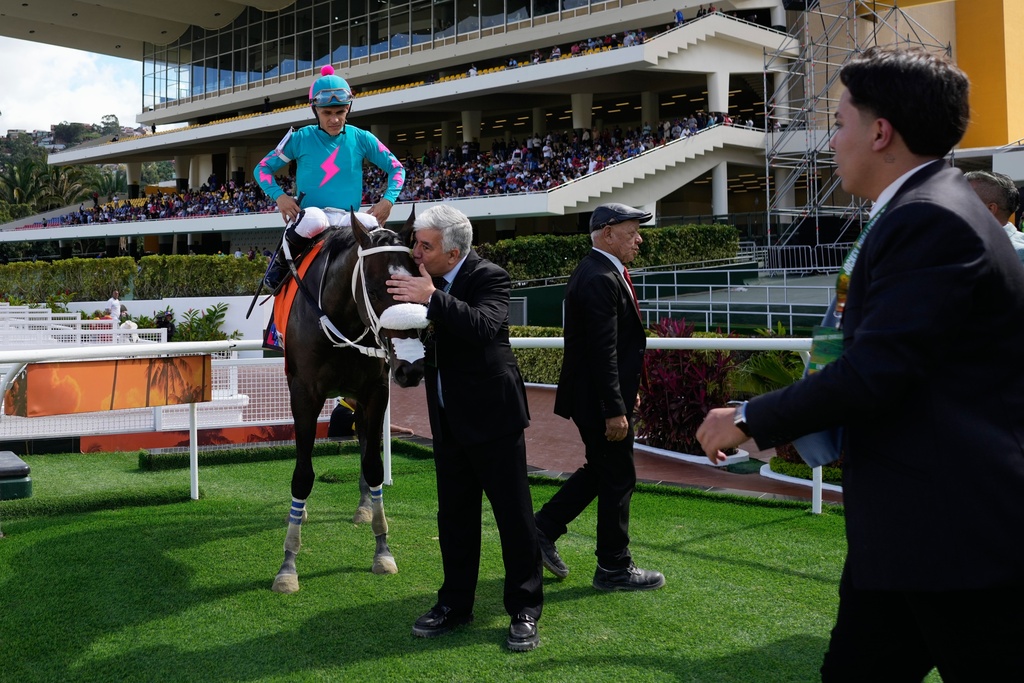 An owner kisses Latina Parts during the 56th Jockey Challenge at the Rinconada racetrack in Caracas, Venezuela, Sunday, Dec. 14, 2025. (AP Photo/Ariana Cubillos)