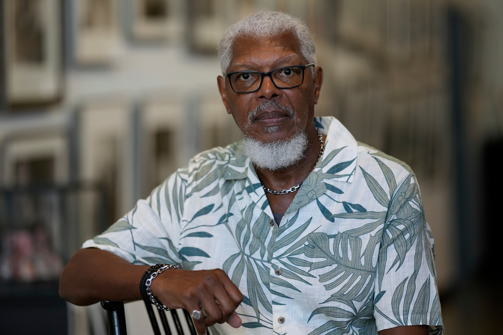 Joe Calhoun poses in front of historical photos of the National Guard during the 1968 sanitation strike, Monday, Sept. 29, 2025, in Memphis, Tenn. (AP Photo/George Walker IV)