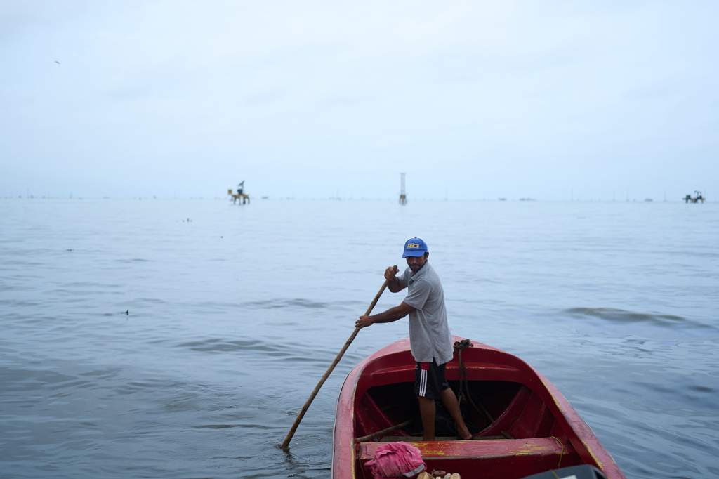 A fisherman steers his boat on Lake Maracaibo in the oil-producing region of Cabimas, Venezuela, Tuesday, Sept. 1, 2026. (AP Photo/Ariana Cubillos)