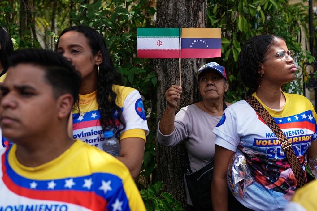 People gather outside the Iranian Embassy to protest against the US-Israeli war, in Caracas, Venezuela, Tuesday, March 3, 2026. (AP Photo/Ariana Cubillos)