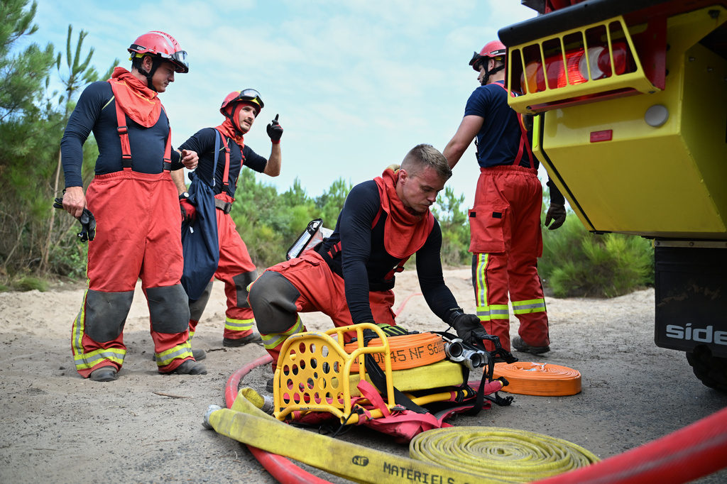 Firefighters put hoses away as they battle fires near Lege-Cap-Ferret, southwestern France, Friday, July 31, 2026. (AP Photo/Emma Da Silva)