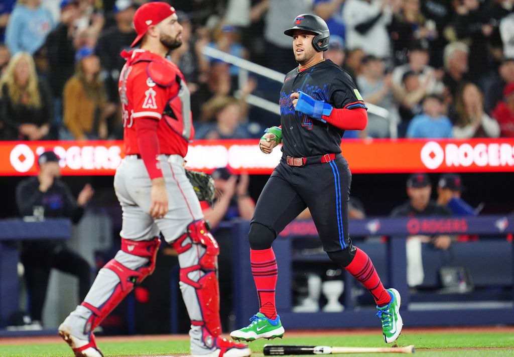 Toronto Blue Jays designated hitter George Springer (4) scores as Los Angeles Angels catcher Sebastian Rivero, left, looks on during third-inning baseball game action in Toronto, Friday, May 8, 2026. (Frank Gunn/The Canadian Press via AP)