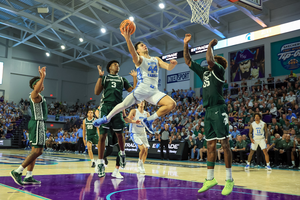 North Carolina guard Luka Bogavac (44) drives against Michigan State forward Coen Carr, front right, during the first half of an NCAA college basketball game Thursday, Nov. 27, 2025, in Fort Myers, Fla. (AP Photo/Mike Carlson)