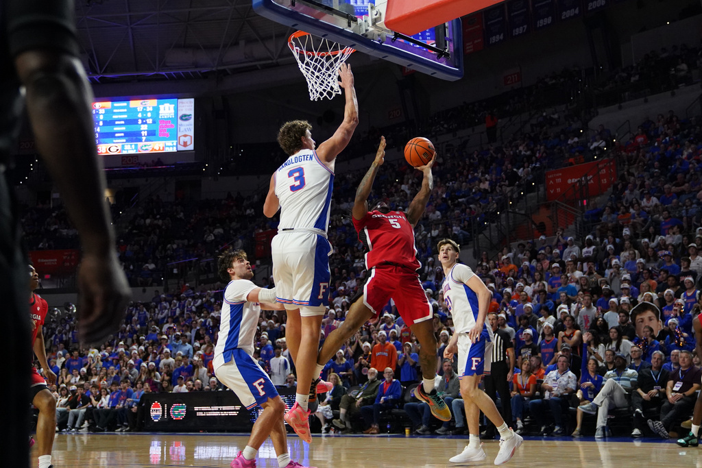 Georgia guard Jeremiah Wilkinson attempts to shoot as Florida center Micah Handlogten blocking during the first half of an NCAA college basketball game Tuesday, Jan. 6, 2026, in Gainesville, Fla. (AP Photo/Morgan Hurd)