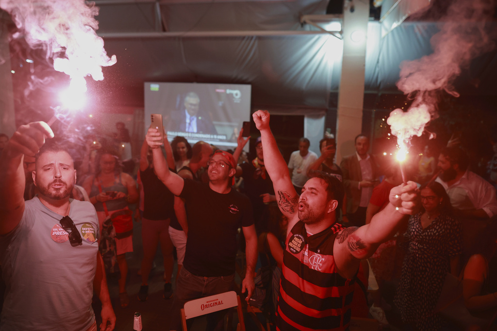 Opponents of former President Jair Bolsonaro celebrate at a bar after the Supreme Court sentenced him to more than 27 years in prison for attempting a coup to remain in office despite his 2022 electoral defeat, in Brasilia, Brazil, Thursday, Sept. 11, 2025. (AP Photo/Luis Nova)