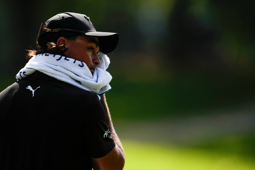 Rickie Fowler wipes his face in the heat off the fifth tee box during the first round of the St. Jude Championship golf tournament, Thursday, Aug. 13, 2026, in Memphis, Tenn. (AP Photo/George Walker IV)