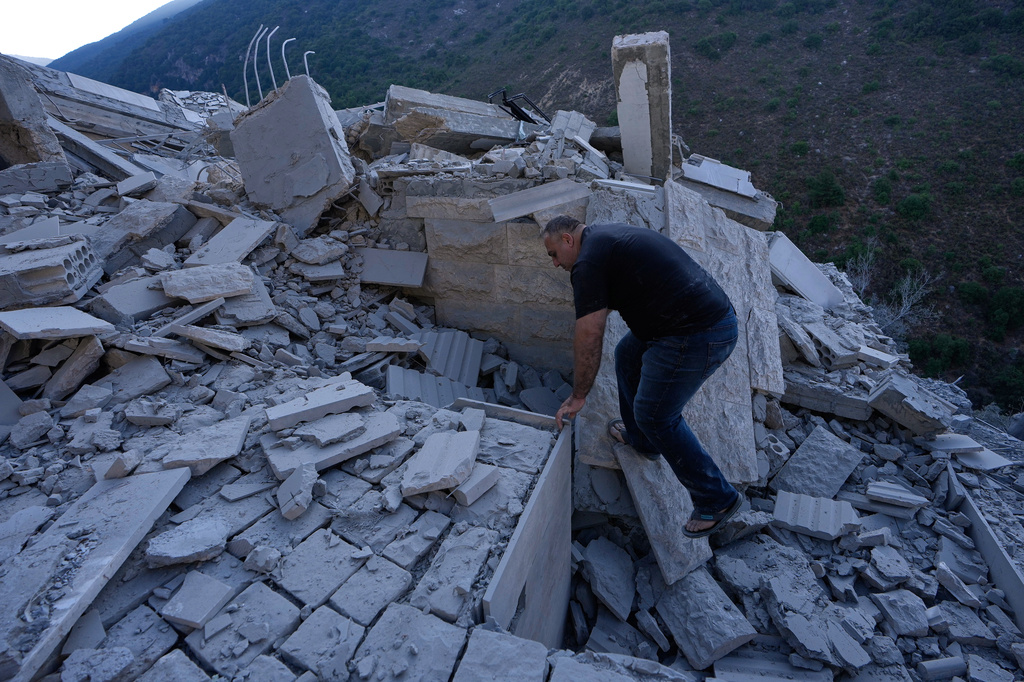 A man searches between the rubble of a destroyed house that was hit by an Israeli airstrike in Arab Salim village, southern Lebanon, Sunday, Sept. 6, 2026. (AP Photo/Mohammed Zaatari)