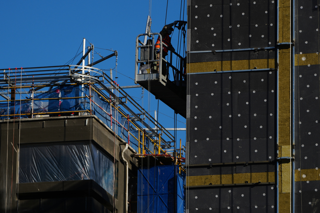 A worker on a scaffolding installs insulation layers on a residential building under construction, in Beijing, Wednesday, Dec. 3, 2025. (AP Photo/Andy Wong)