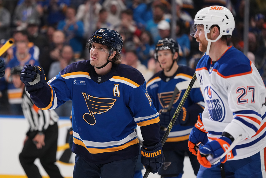 St. Louis Blues' Robert Thomas, left, skates past Edmonton Oilers' Brett Kulak (27) after scoring during the second period of an NHL hockey game Monday, Nov. 3, 2025, in St. Louis. (AP Photo/Jeff Roberson)