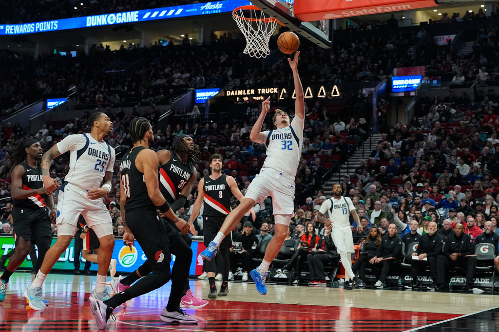 Dallas Mavericks forward Cooper Flagg (32) shoots during the first half of an NBA basketball game against the Portland Trail Blazers, Friday, March 27, 2026, in Portland, Ore. (AP Photo/Jenny Kane)