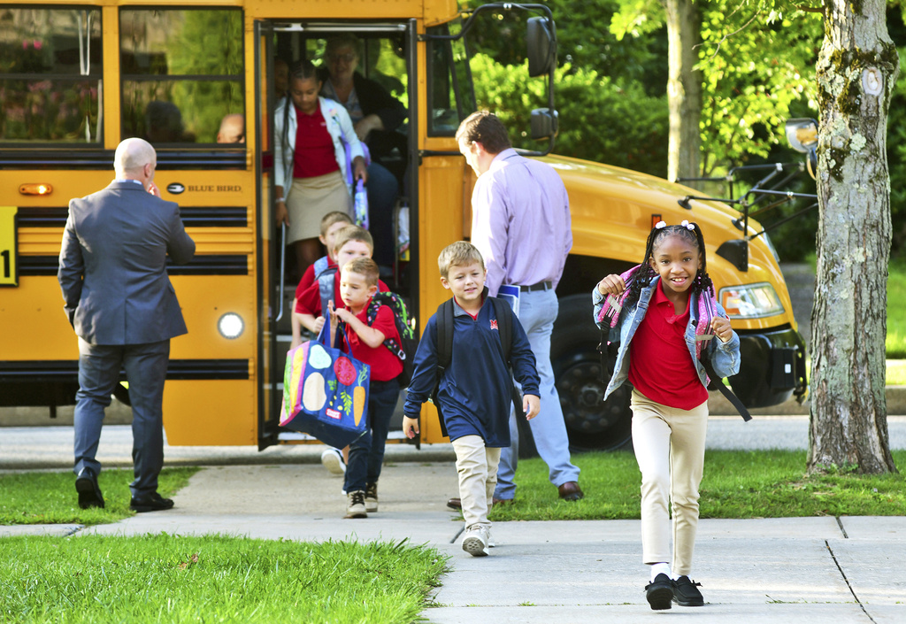 FILE - Second-grader Aaminah Ingram-Kirk, 7, leads the way off the bus for the first day of school at Bishop McCort Catholic Elementary West on Tioga Street in Johnstown, Pa., Aug. 21, 2024. (Thomas Slusser/The Tribune-Democrat via AP, File)