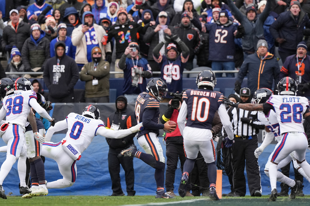 Fans react as Chicago Bears quarterback Caleb Williams (18) scores a touchdown during the second half of an NFL football game against the New York Giants, Sunday, Nov. 9, 2025, in Chicago. (AP Photo/Nam Y. Huh)