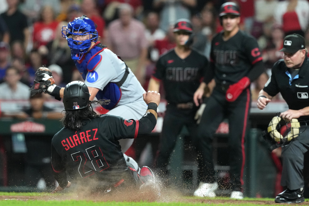 Cincinnati Reds' Eugenio Suarez scores on a single by Jose Trevino, not pictured, during the sixth inning a baseball game against the Chicago Cubs, Friday, Sept. 18, 2026, in Cincinnati. (AP Photo/Kareem Elgazzar)