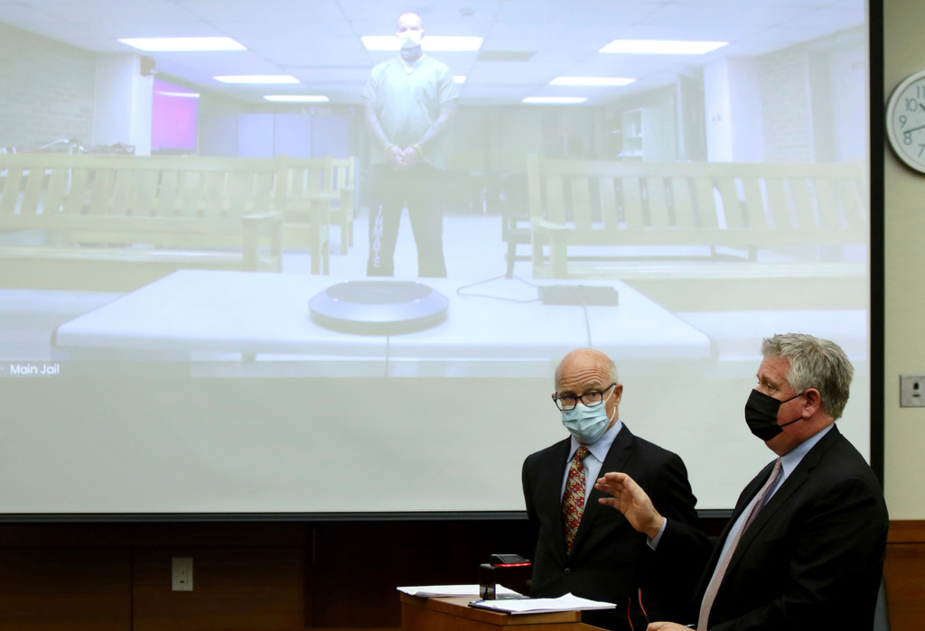 FILE - Defense attorney Mark Collins, right, speaks to the judge as defense attorney Steve Nodler, center, listens during the arraignment of former Franklin County, Ohio, deputy Jason Meade, appearing on video screen, Dec. 3, 2021, in Columbus, Ohio. (AP Photo/Paul Vernon, File)