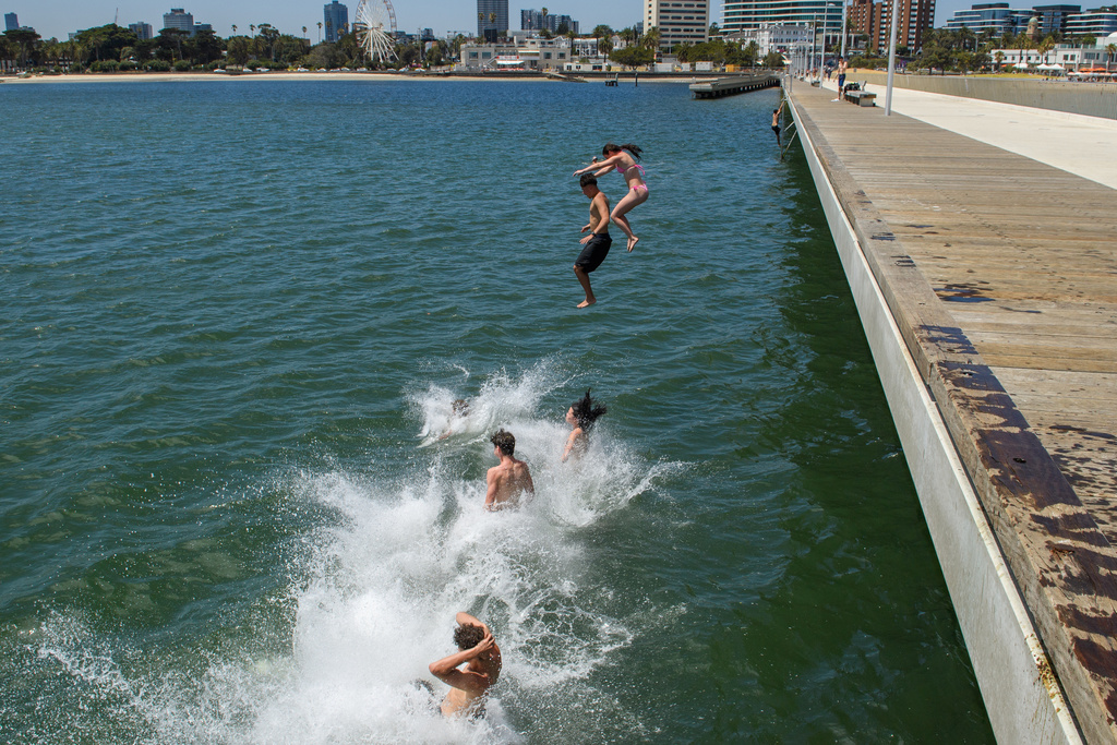 A group of young people leap into the water from St. Kilda Pier in Melbourne, Australia, Tuesday, Jan. 27, 2026, as temperatures soar. (Michael Currie/AAP Image via AP)