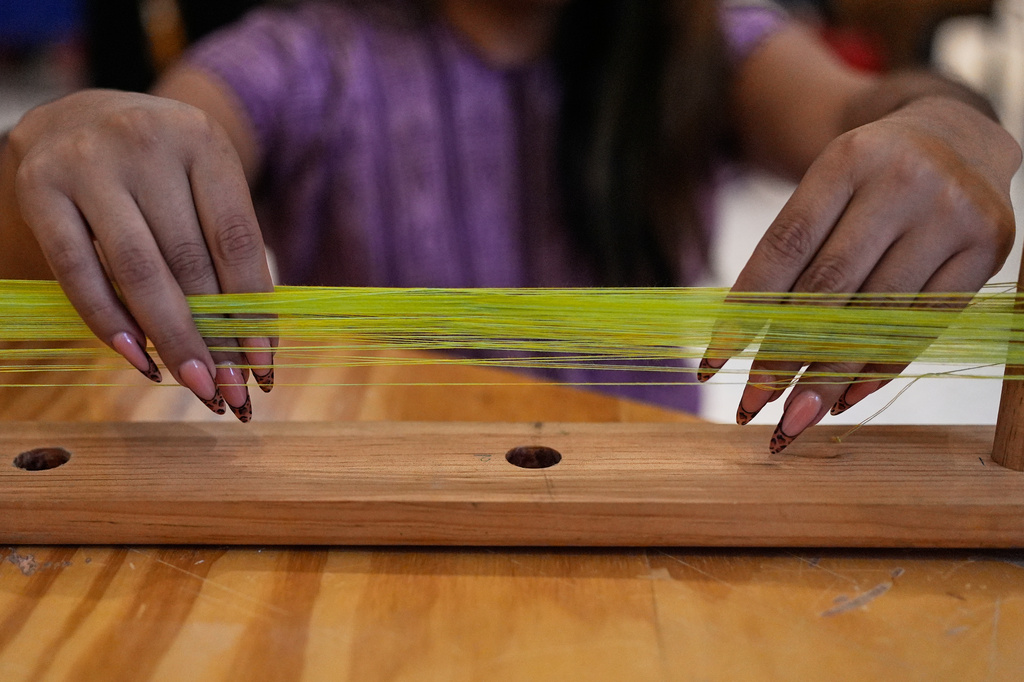 Muxe artist Xaneri Merino gives a backstrap loom workshop for LGBTQ+ people in Mexico City, Tuesday, April 14, 2026. (AP Photo/Marco Ugarte)