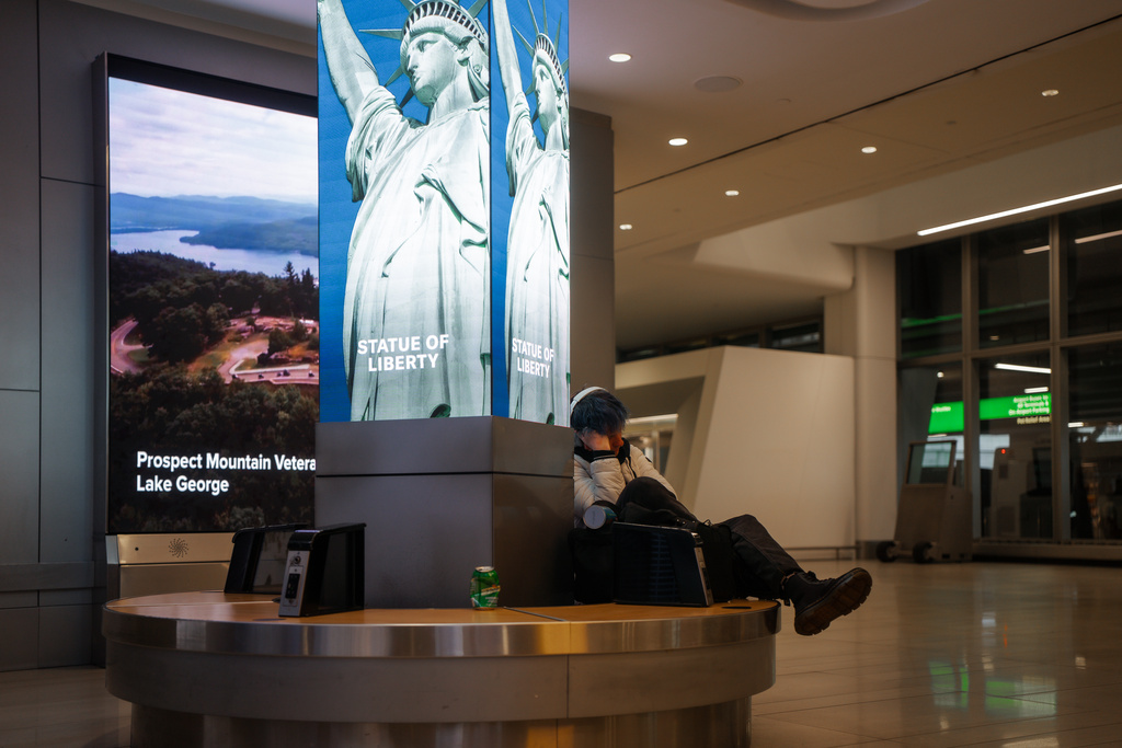 A traveler sleeps at Laguardia International Terminal on Saturday, Nov. 8, 2025, in New York. (AP Photo/Olga Fedorova)